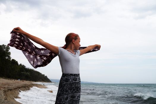 teenage girl with a handkerchief fluttering in the wind in her hands.