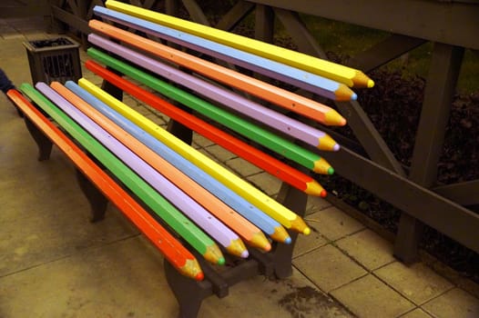 multicolored bench made of boards in the form of colored pencils.