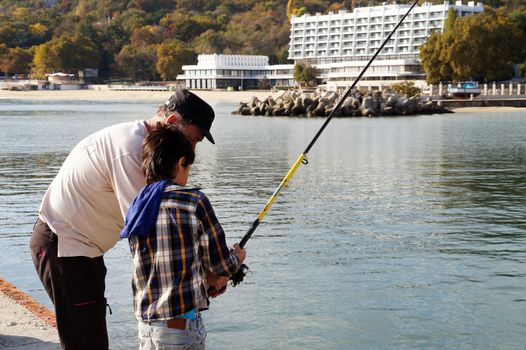 Varna, Bulgaria - November, 11, 2020: a man teaches his son to fish