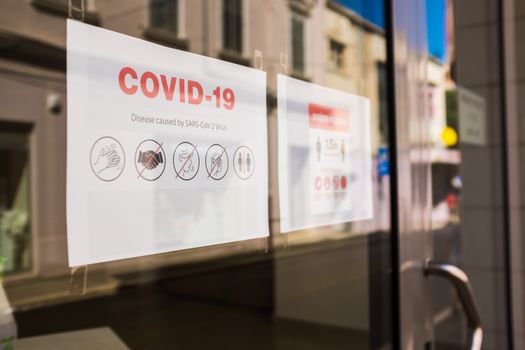 COVID-19 safety measures notice on store window,information on shop door to inform people of Coronavirus measures and regulations for prevention & protection of virus spread during pandemic lockdown