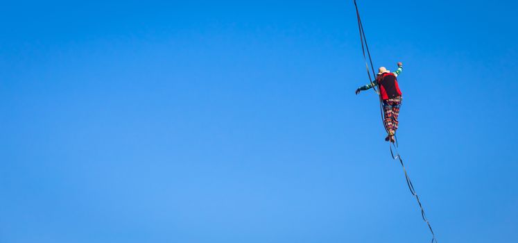 LANZO, ITALY - CIRCA OCTOBER 2020: Slackline athlete during his performance. Concentration, balance and adventure in this dynamic sport.