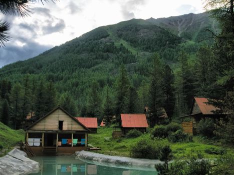A small tourist base with wooden houses in the forests of the Altai Mountains.