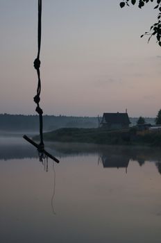 Rope for diving from a tree in the background of the lake.