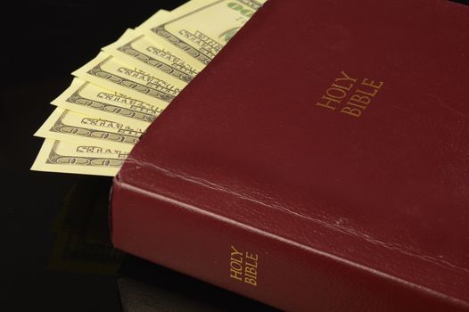 A wise person has stashed some cash money into their Bible pages for safe keeping.