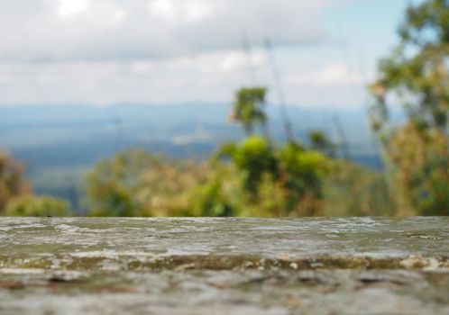 The iron table is empty on the background of forest, mountain and sky.