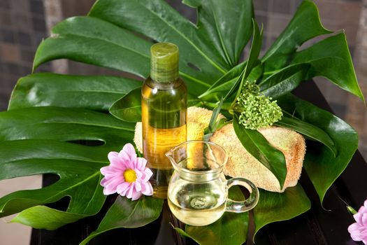 Oil, towels and green leaves on a wooden desk