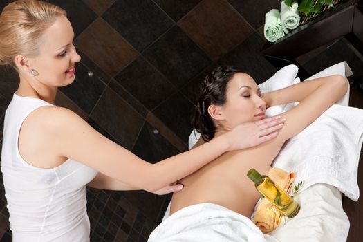 Young attractive woman taking massage and spa procedures