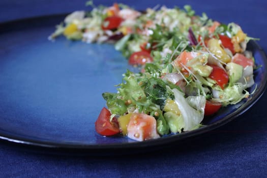 Fresh vegetable salad on a blue background.Texture or background