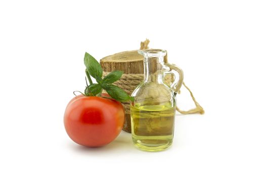 Fresh cherry tomato and basil leaf and oil in decanter over a white background in a healthy diet and nutrition concept