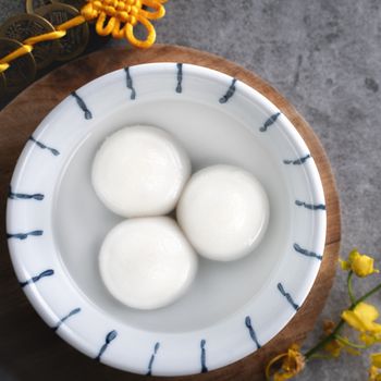 Top view of big tangyuan yuanxiao (glutinous rice dumpling balls) for lunar new year festival food, words on the golden coin means the Dynasty name it made.