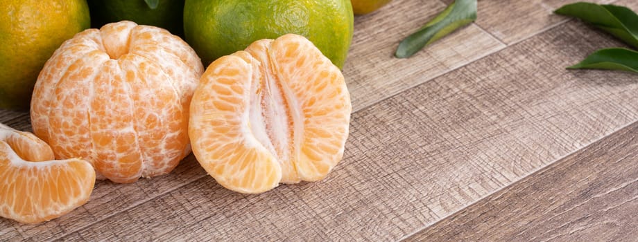 Fresh ripe tangerine mandarin orange in a box wite fresh leaves on wooden table background harvest concept.