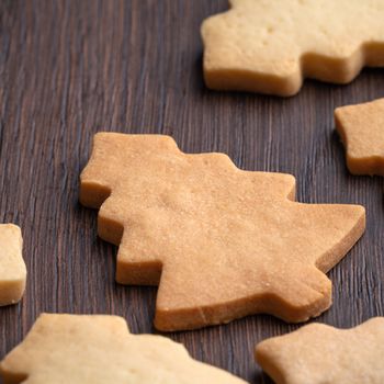 Top view of decorated Christmas tree gingerbread cookie on wooden table background with copy space, concept of holiday celebration.