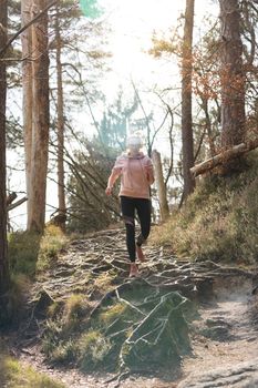 Active sporty woman running in autumn fall forest. Female runner training outdoor. Healthy lifestyle image of young caucasian woman jogging outside. Active, healthy lifestyle concept.