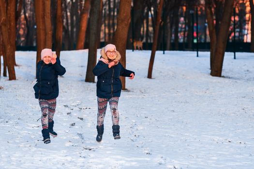 Beautiful teenage girls having fun in the forest in winter