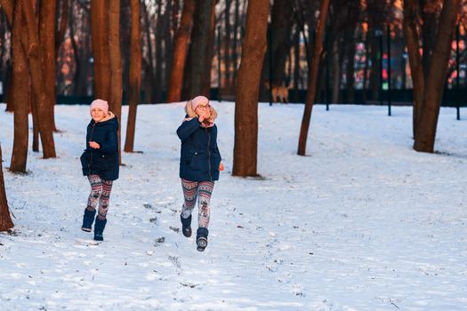 Beautiful teenage girls having fun in the forest in winter