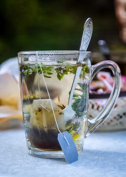 Transparent mug with tea. Brewing tea in a bag. Brewing herbal tea. Herbal tea.