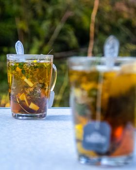 Transparent mug with tea. Brewing tea in a bag. Brewing herbal tea. Herbal tea.