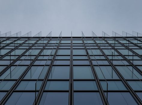 Upward view to wall of high glassy corporate building