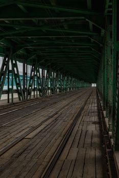 Long wooden and metal bridge with tram rails and green construction