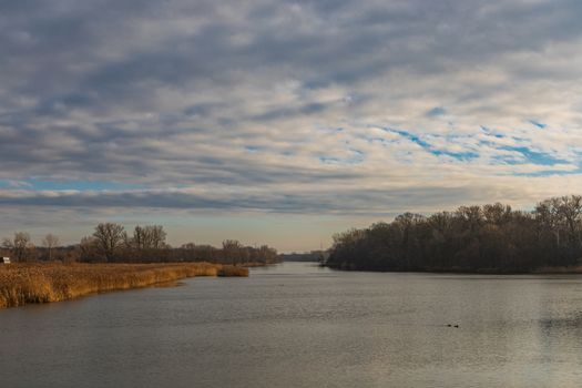 Cloudy landscape over Odra river with yellow coast and trees around