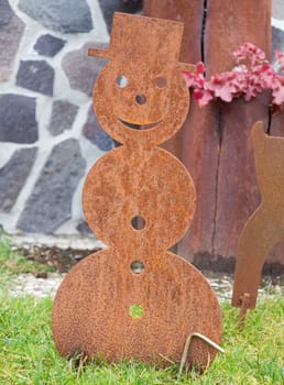 Rusty metal snowmann shape in the garden