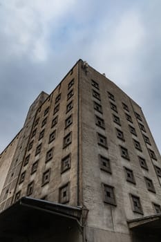 Upward view to old industrial building with holes in windows