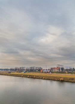 Long yellow coast near Odra river with few trees and buildings