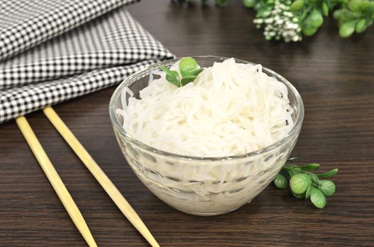 Konjac or Shirataki noodles with Chinese chopsticks. Japanese traditional dish. Healthy food for weight loss, keto diet concept.