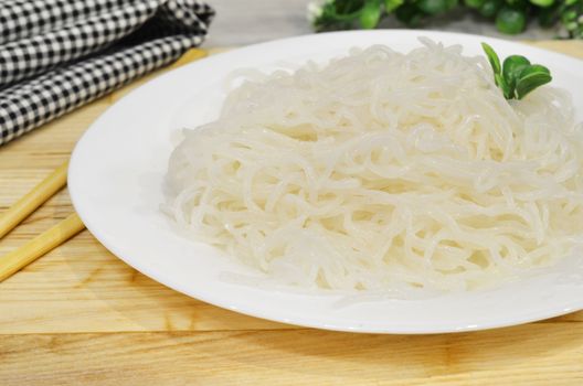 Konjac or Shirataki noodles with Chinese chopsticks. Japanese traditional dish. Healthy food for weight loss, keto diet concept.