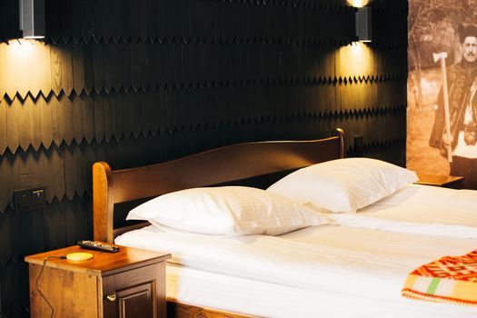 Exquisite Interior in a Cozy Place. Wooden Bed of a Modern Hotel Room.