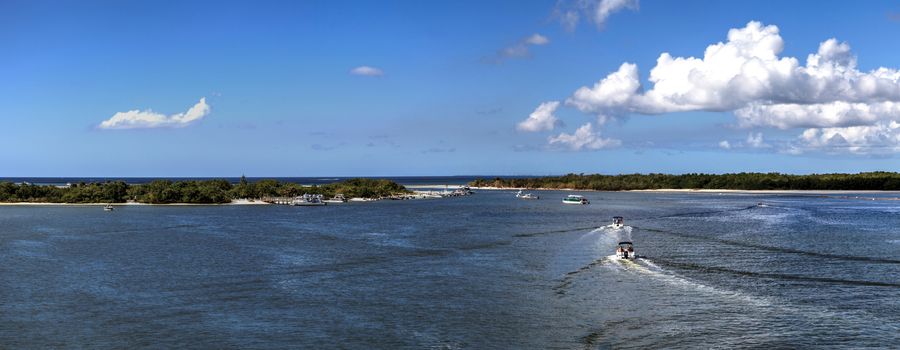 Boats sail through New Pass of Estero Bay toward the ocean and Lovers Key State Park on the edge of Bonita Springs and Fort Myers, Florida.