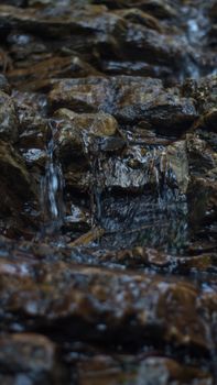 Close up of mountain river flows between picturesque summer stones. Rocks in the mountains with water flowing