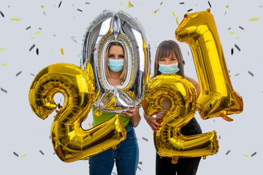 Happy friends celebrate the New Year 2021 with face masks