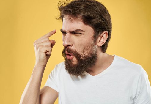 irritable young man with beard on yellow background cropped view. High quality photo