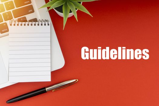 GUIDELINES text with notepad, laptop, fountain pen and decorative plant on red background. Business and Copy Space Concept