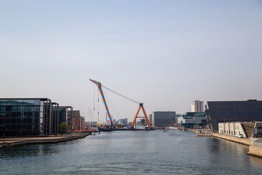 Copenhagen, Denmark - April 4, 2019: The huge Floating Crane Hebo Lift 9 installing parts for a new cycling bridge over the harbour.
