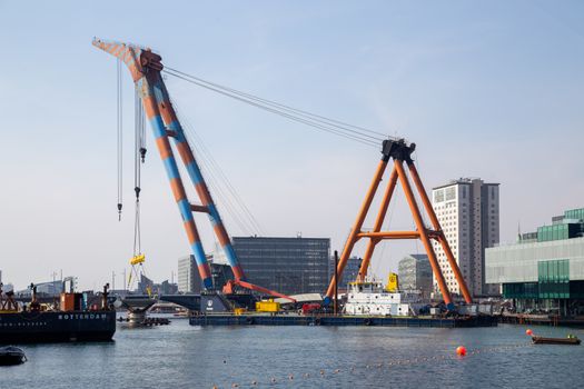 Copenhagen, Denmark - April 4, 2019: The huge Floating Crane Hebo Lift 9 installing parts for a new cycling bridge over the harbour.