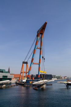 Copenhagen, Denmark - April 4, 2019: The huge Floating Crane Hebo Lift 9 installing parts for a new cycling bridge over the harbour.