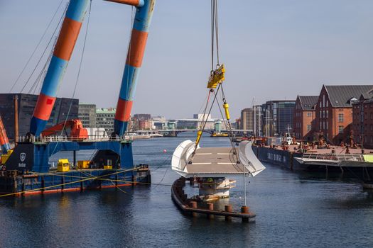 Copenhagen, Denmark - April 4, 2019: The huge Floating Crane Hebo Lift 9 installing parts for a new cycling bridge over the harbour.