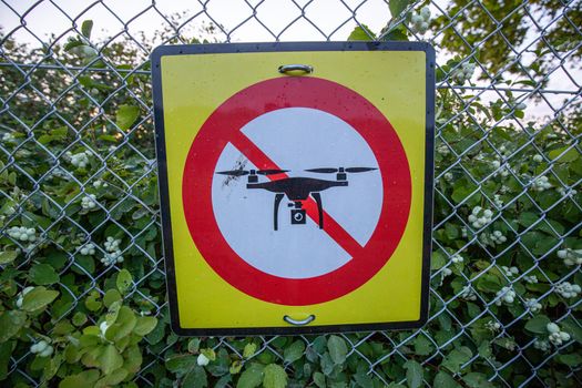 A no drone warning sign mounted at a fence.