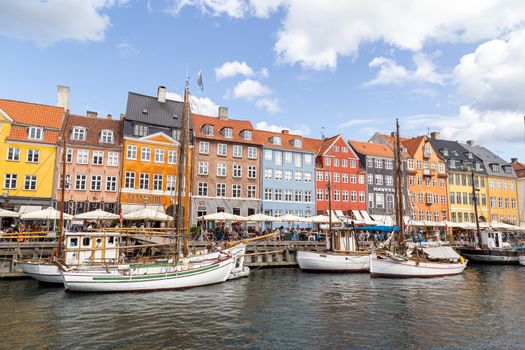 Copenhagen, Denmark - August 21, 2019: Famous Nyhavn district in the city centre with colorful houses.