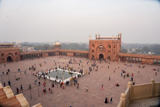 Delhi, India - December 04, 2019: Square with people and entrance gates infront of Jama Masjid.