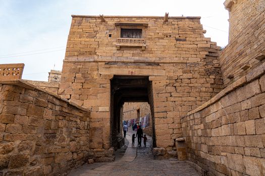 Jaisalmer Fort, India - December 5, 2019: People walking through a big entrance gate at the historic fort.
