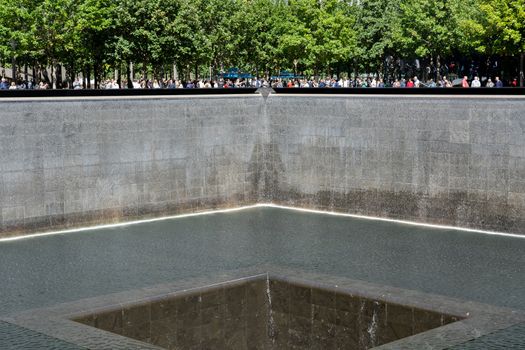 New York, United States of America - September 19, 2019: People standing at the north pool of the World Trade Center Ground Zero Memorial in Lower Manhattan.