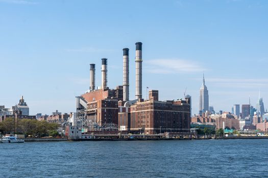 NYC, USA - September 23, 2019: Con Edison Power Plant in Mahattan and Empire State Building in the background.