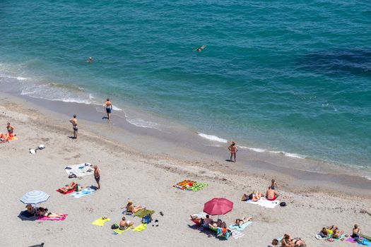 Nerja, Spain - May 28, 2019: People enjoying the sun at Calahonda Beach.