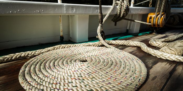 Sailboat nautical mooring rope on wet wooden deck, panoramic view