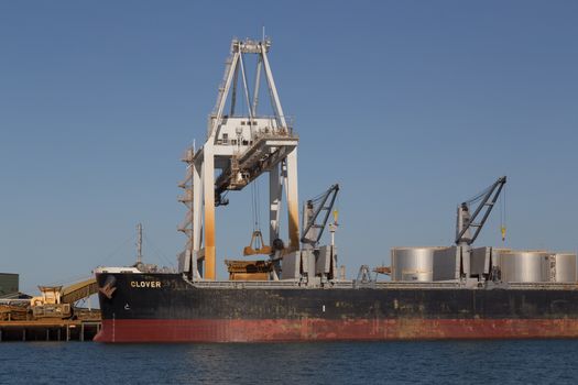 Townsville, Australia - May 11, 2015: Cargo ship is being unloaded at container terminal.