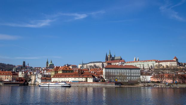 Prague, Czech Republic - March 16, 2017: Vlata River Water front with Prague Castle in the background
