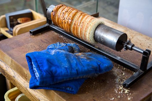 Prague, Czech Republic - March 18, 2017: Famous Czech pastry Trdelnik being baked in a street bakery. Trdelnik, also called Trdlo is a sugary sweet pastry.
